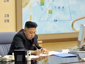 A picture of Kim Jong Un with a iMac on his desk.